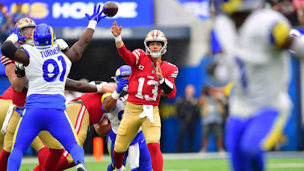 Sep 17, 2023; Inglewood, California, USA; San Francisco 49ers quarterback Brock Purdy (13) throws under pressure from Los Angeles Rams defensive tackle Kobie Turner (91) during the first half at SoFi Stadium. Mandatory Credit: Gary A. Vasquez-USA TODAY Sports